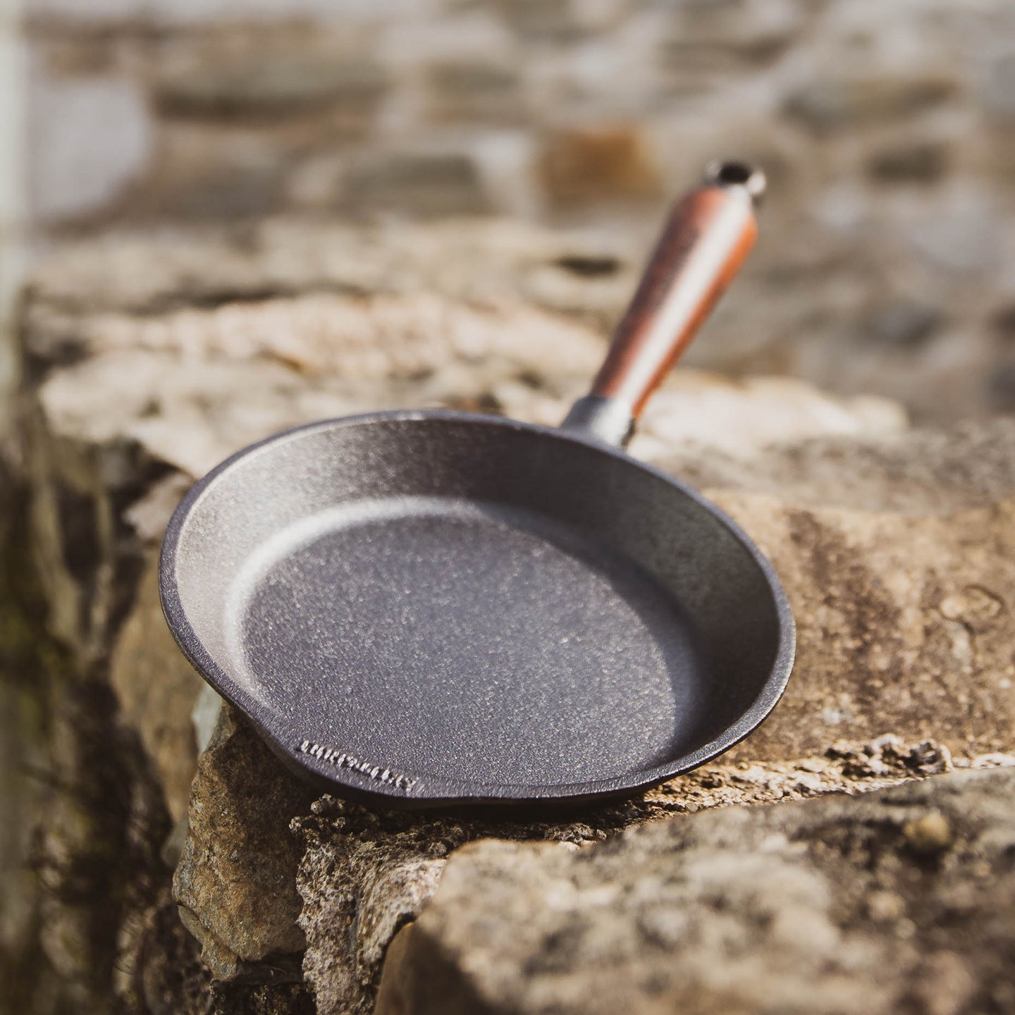 Stylish and durable cast iron frying pan with walnut handle, perfect for everyday cooking and heat retention.